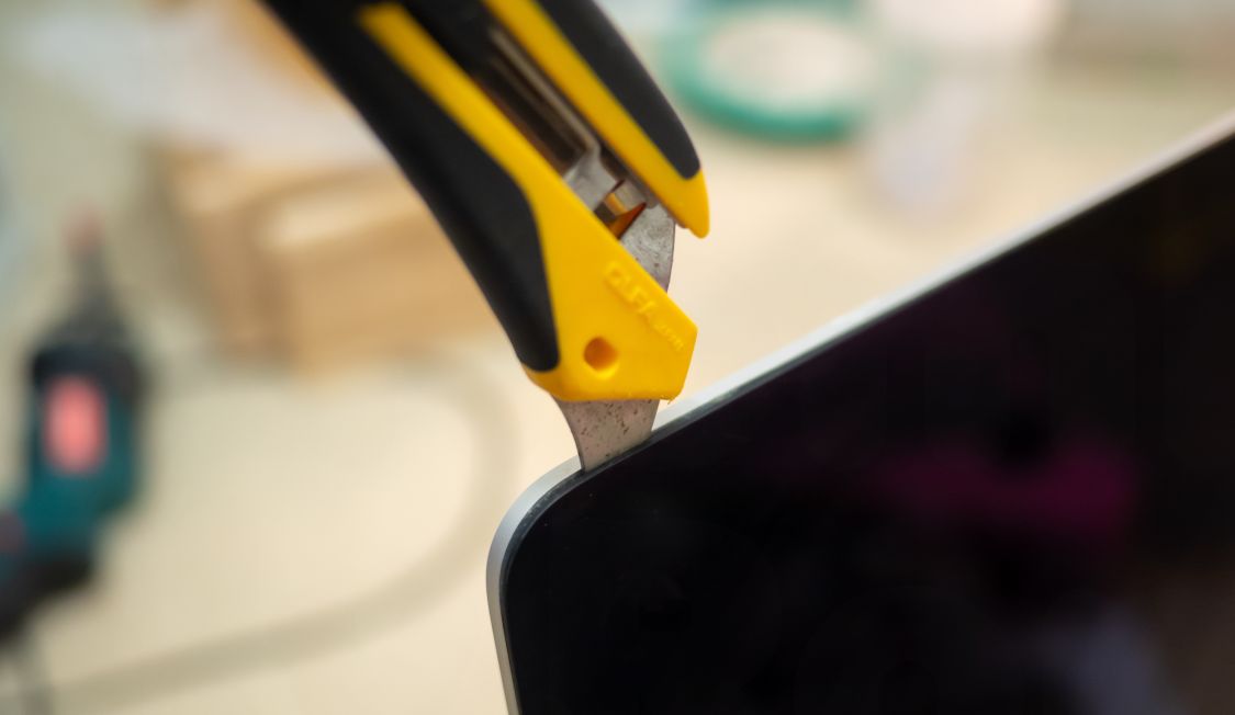 液晶パネルをカッターで取り外そうとしている写真